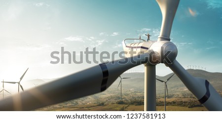Happy engineer feel success after good work. He standing a top of windmill and looking beautiful sunset landscape Royalty-Free Stock Photo #1237581913