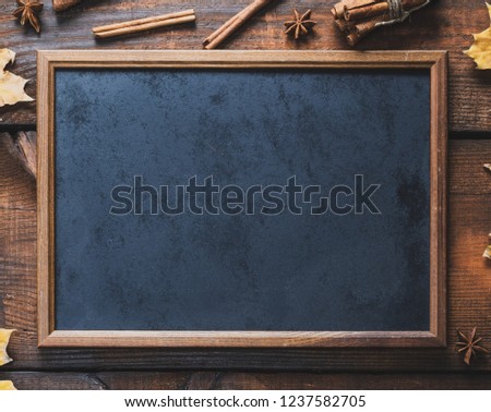 empty black chalk frame on brown wooden background, copy space