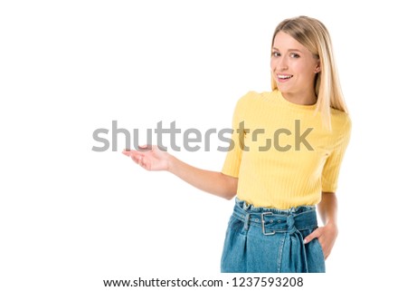 happy young woman showing copy space and smiling at camera isolated on white