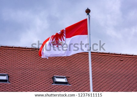 The flag of the German state of Brandenburg is blowing in the wind