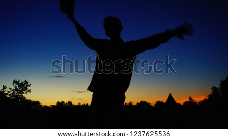 stylish man like dancing when taking a silhouette picture with a sunrise background