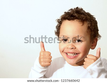 little boy showing thumbs up gesture with his hands on white background stock photography stock photo