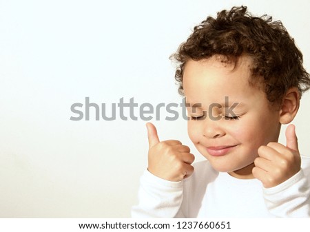 little boy showing thumbs up gesture with his hands on white background stock photography stock photo