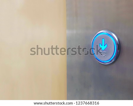 Close up Elevator circle button down direction with blue light on wall. Copy space