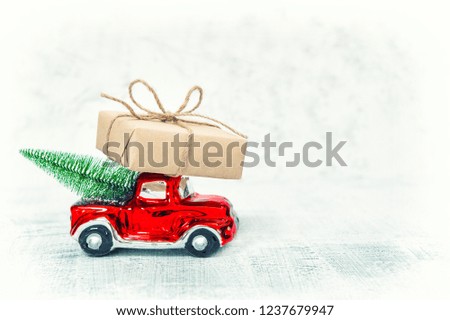 Red car with gift box and Christmas tree. Vintage toned picture