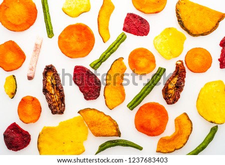 Dried vegetables chips from carrot, beet, parsnip and other vegetables isolated on white background. Organic diet and vegan food. Flat lay.