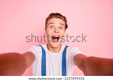 Closeup photo portrait of comic humorous funny with open mouth boy in overalls take make selfie user using smartphone