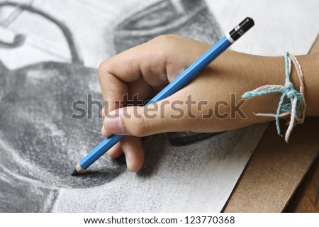 Boy hands with pencil,drawing on white paper