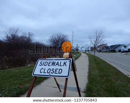 Sidewalk closed sign on walkway leading off into the distance. 