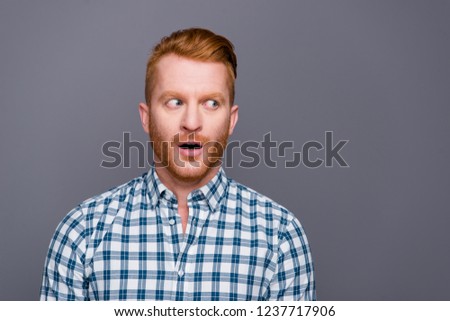 Close-up portrait of nice shocked funny handsome attractive trendy man with beard stubble bristle wearing checkered shirt opened mouth looking aside isolated over grey pastel background