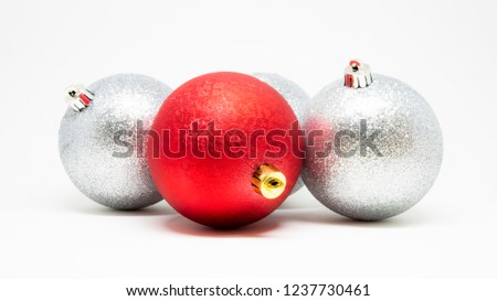 Set of glittering Christmas tree decoration balls isolated on a light background, red one highlighted