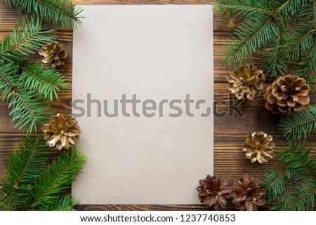 Christmas holiday background. Empty card for greeting. FIr tree, golden cones. Brown table background. Free space for text. 
