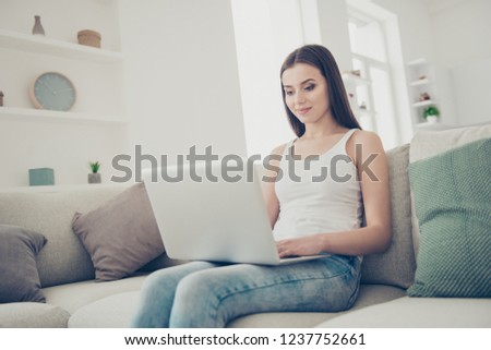 Photo portrait of dreamy carefree careless lady with her kind cool smile she sit on couch sofa indoor cozy fancy bright living room flat look at notebook screen