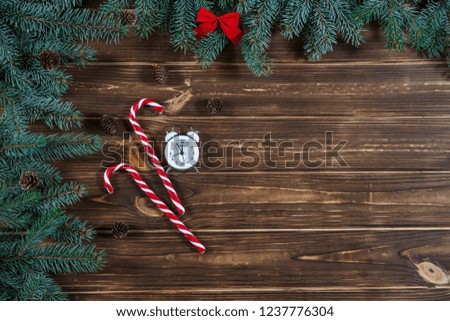 Christmas holiday background with vintage alarm-clock, Candy canes wooden background. Close-up, top view. Christmas and New Year concept