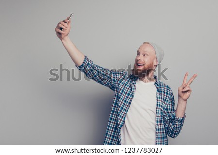 Nice handsome cool man in casual checkered style stylish trendy shirt take picture on cellular give v-sign stand isolated on light gray background