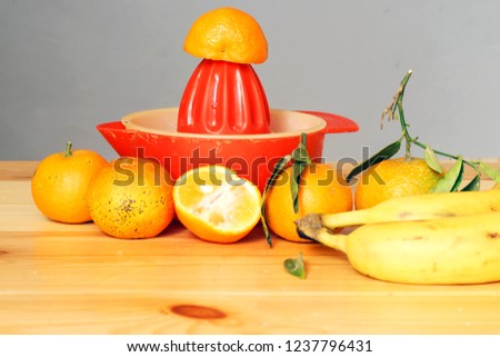  making fresh orange juice and   banana smoothie. mixing ingredients together. Simple elegant picture with copy space.
