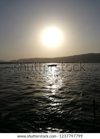 Boat in sunset reflection at Anaa Saagar (Lake) situated in Ajmer, Rajisthan, India.
