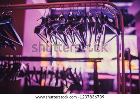 Stock of empty clothes hanger in wardrobe, wooden coat Hangers hanging on a cloth rail rack in closet hotel bedroom. Abstract for show of suits shop after clearance sales.