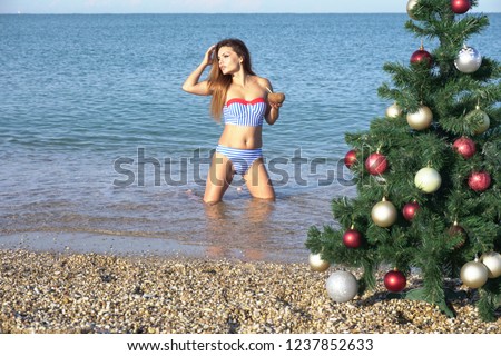 a beautiful woman in a swimsuit sea Christmas new year tree vacation