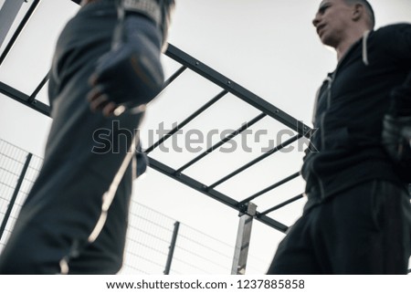 Calm young man wearing sports clothes and standing outdoors in front of the professional boxer