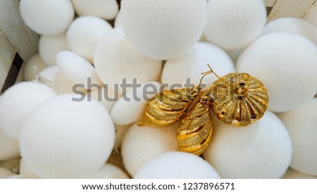 Beautiful Christmas ornaments. Christmas decoration in the form of the golden ball with glitter ornament, in the background, many whites Christmas balls.