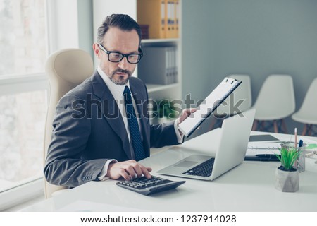 Banker broker man in formal wear sit on chair armchair behind desktop with modern technology in bright lite workplace office keeps economic records Royalty-Free Stock Photo #1237914028