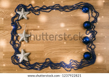 Top View  of different Christmas Decorations with silver and blue color on Wooden Background with snow flake effect