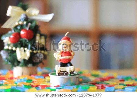 Candle Santa Claus on table in library A small Christmas tree is the background selective focus and shallow depth of field
