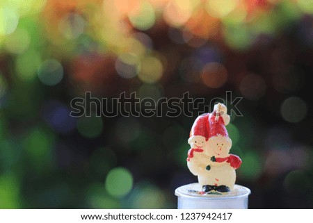 Candle snowman colorful bokeh is the background