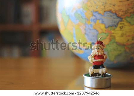 Candle Santa Claus on table in library The globe is the background selective focus and shallow depth of field