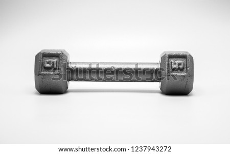 a well worn 5 pound dumbbell with numbers displayed isolated on white