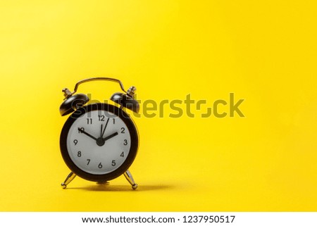 Ringing twin bell vintage classic alarm clock isolated on yellow colourful trendy modern fashion background. Rest hours time of life good morning night wake up awake concept. Copy space
