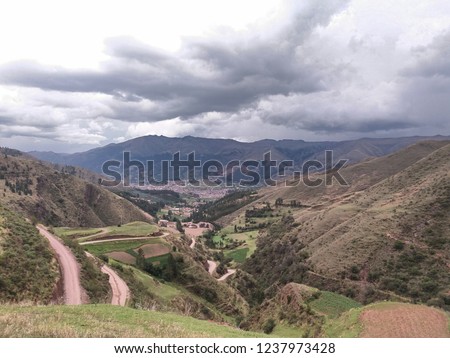 
road crossing mountain, trees and nearby bushes, cloudy sky background, location, San Jeronimo, Cusco, Peru.