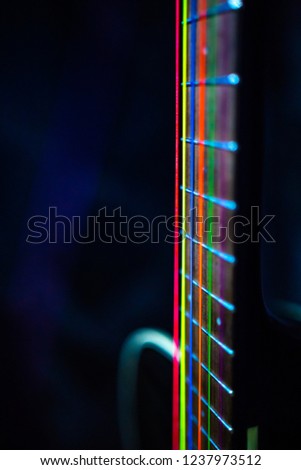 colorful acoustic guitar strings on black guitar and dark background