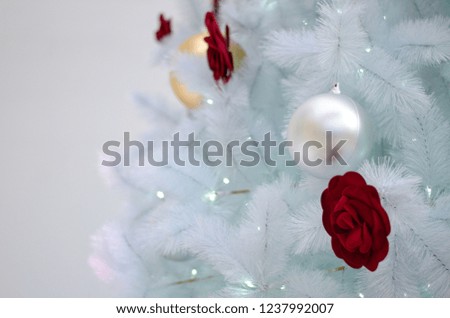White Christmas tree decorates with red rose and other ornament for Christmas holiday.