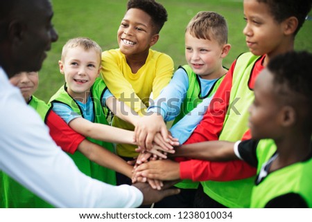 Junior football team stacking hands before a match Royalty-Free Stock Photo #1238010034