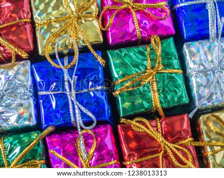 Close-up small colorful gift boxes. Top view of many gifts wrapped colorful shiny paper.