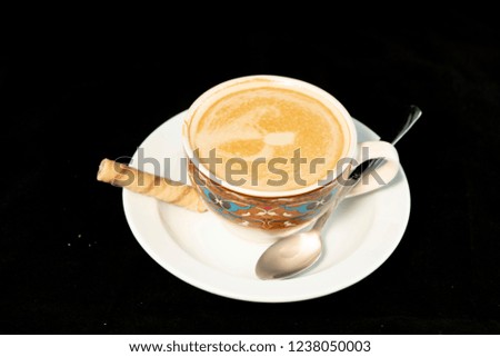 Vanilla latte coffee with wafer rolls with isolated black background