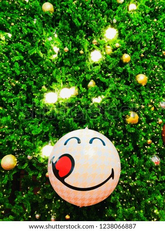 The ball smile on the Christmas tree decorated holiday festival.