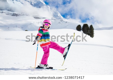 Child skiing in the mountains. Kid in ski school. Winter sport for kids. Family Christmas vacation in the Alps. Children learn downhill skiing. Alpine ski lesson for boy and girl. Outdoor snow fun.