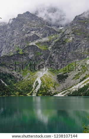 Beautiful mountain slope, rock reflection in mountain lake water in Western Tatras, Tatra mountain, Poland