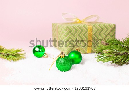Green Christmas New Year balls in the snow and pine branches on pink background Flat Lay copy space. Holiday Baubles, beautiful Decoration Festive decor, celebration Xmas holiday greeting card