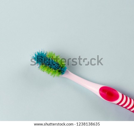 Used old toothbrush close-up on a blue background, top view