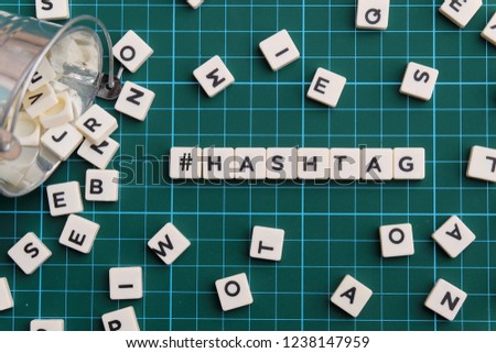 Hashtag word made of square letter word on green square mat background.
