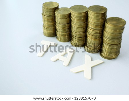 wood text TAX on gold coins background , business and finance concept
