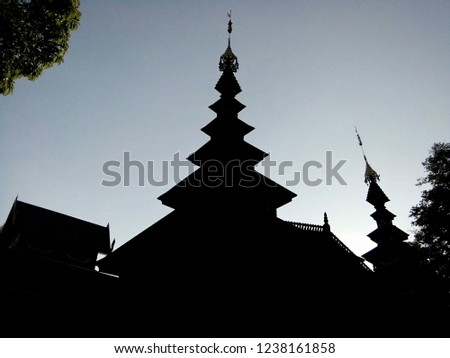 Silhouette of the temple roof that's arranged by tiers in Wat Chom Sawan temple Thailand Phrae. This temple is the national historic site and the old burmese art temple .
