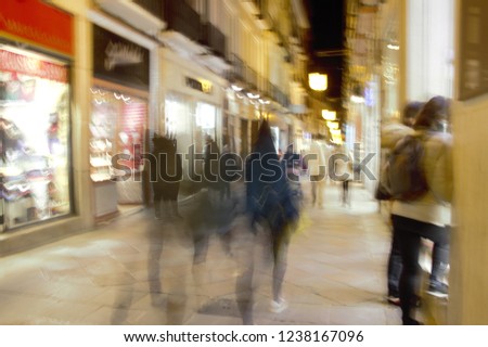 ghostly human figures in old commercial street of Granada, Shopping, night photo, photographic sweep, sensation of movement, blurred people, impressionist photography, abstract, nightlife, atmosphere,