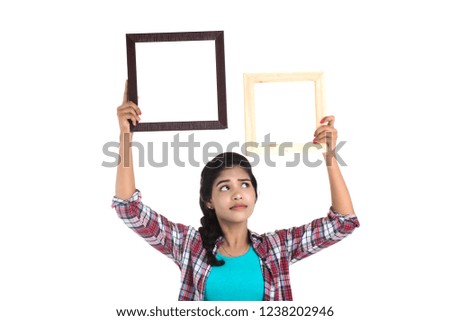 attractive young woman holding and posing with Picture frame on a white background.