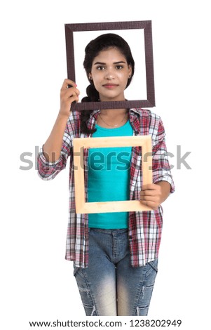 attractive young woman holding and posing with Picture frame on a white background.