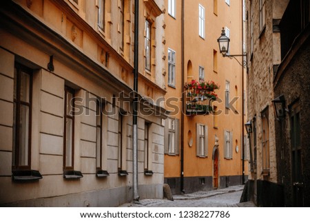  olorful street in Old Town of Stockholm,Sweden,Gamla Stan. Cozy street. Cobblestone road. Orange,yellow houses and street lights. Summer, spring, autumn time. Perspective of the street.